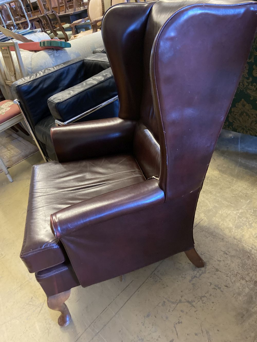 A burgundy leather wing armchair, width 74cm, depth 86cm, height 97cm